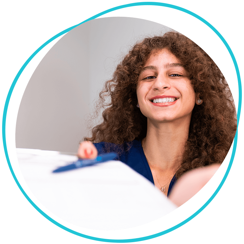 Team member handing insurance forms to Patient