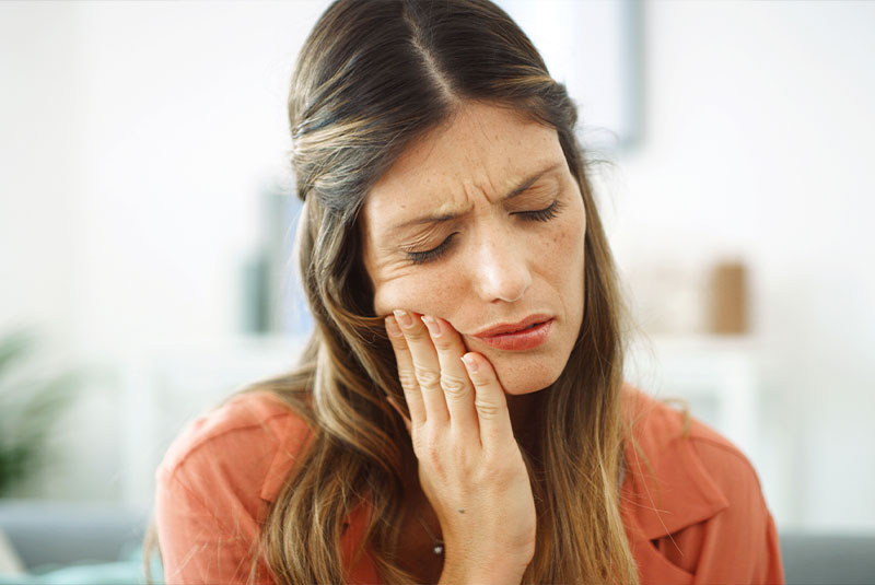Woman holding mouth in pain